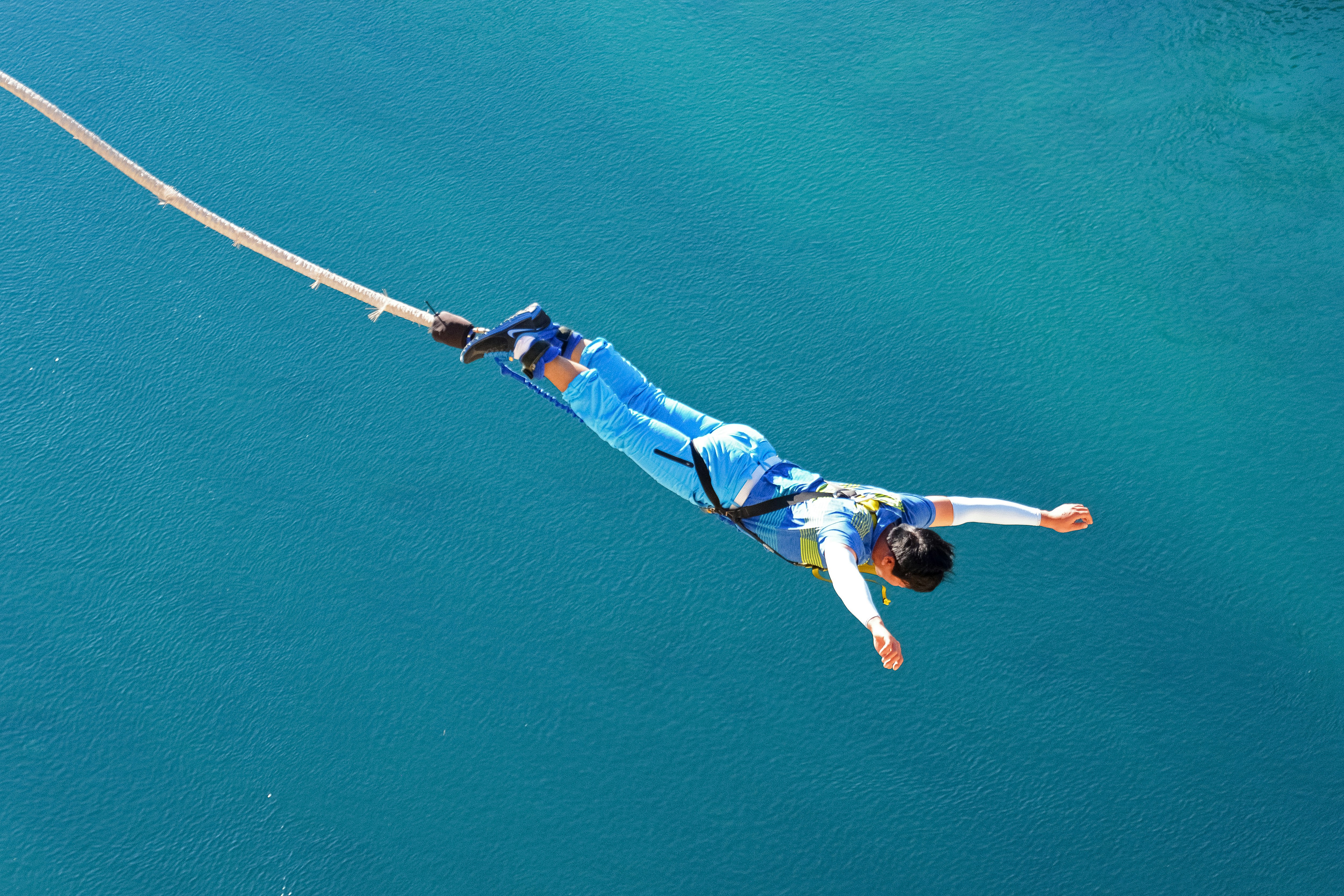 man in blue and white shirt and blue shorts floating on water during daytime