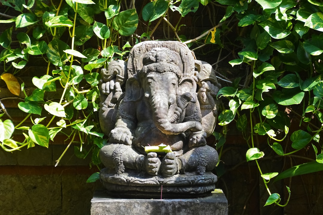 gray concrete statue near green plants