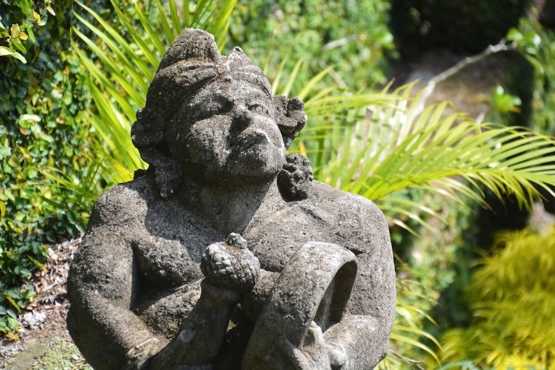 gray stone statue near green grass during daytime