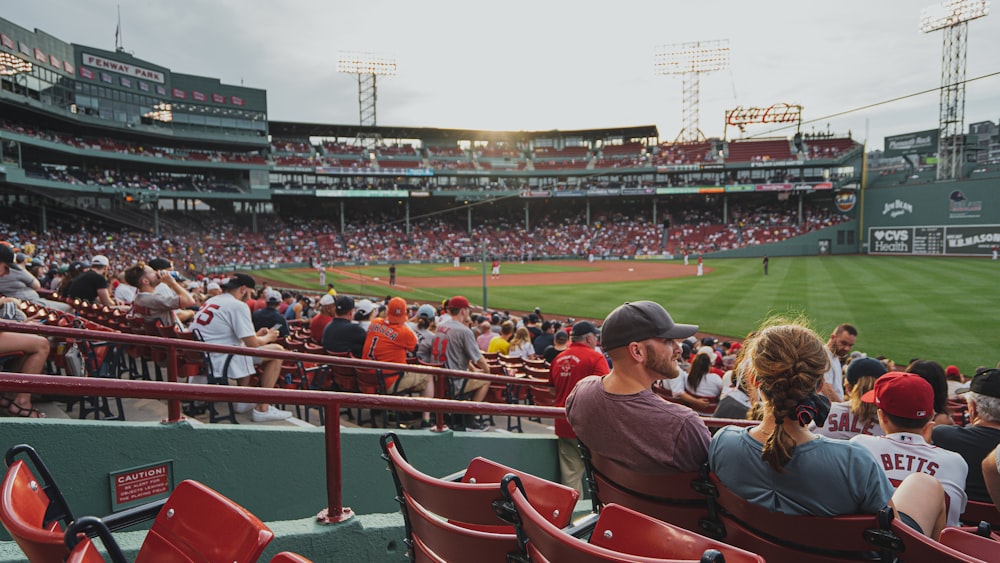 personnes assises sur une chaise rouge regardant un match de baseball pendant la journée