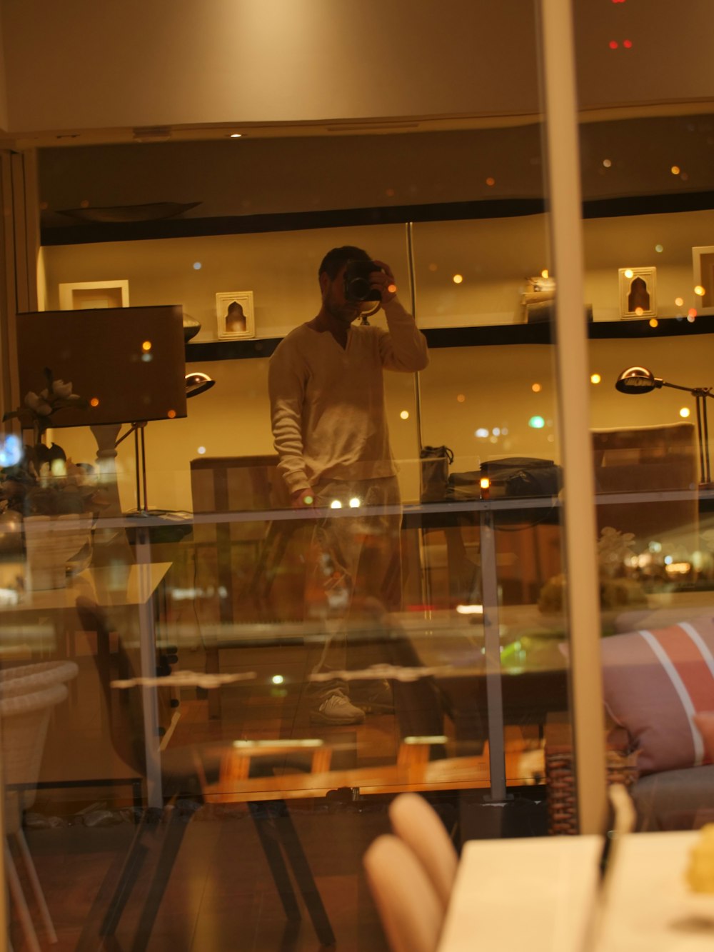 man in white dress shirt and black pants standing near glass wall