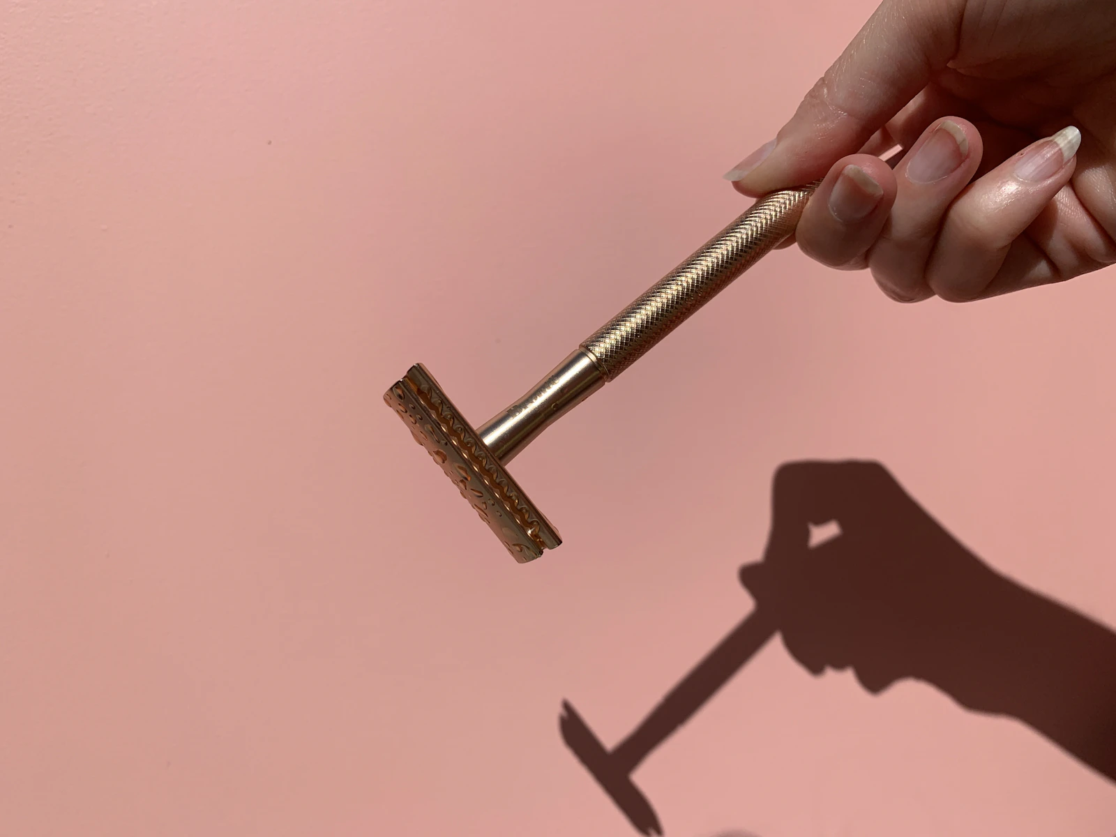 Hand holding a brass safety razor