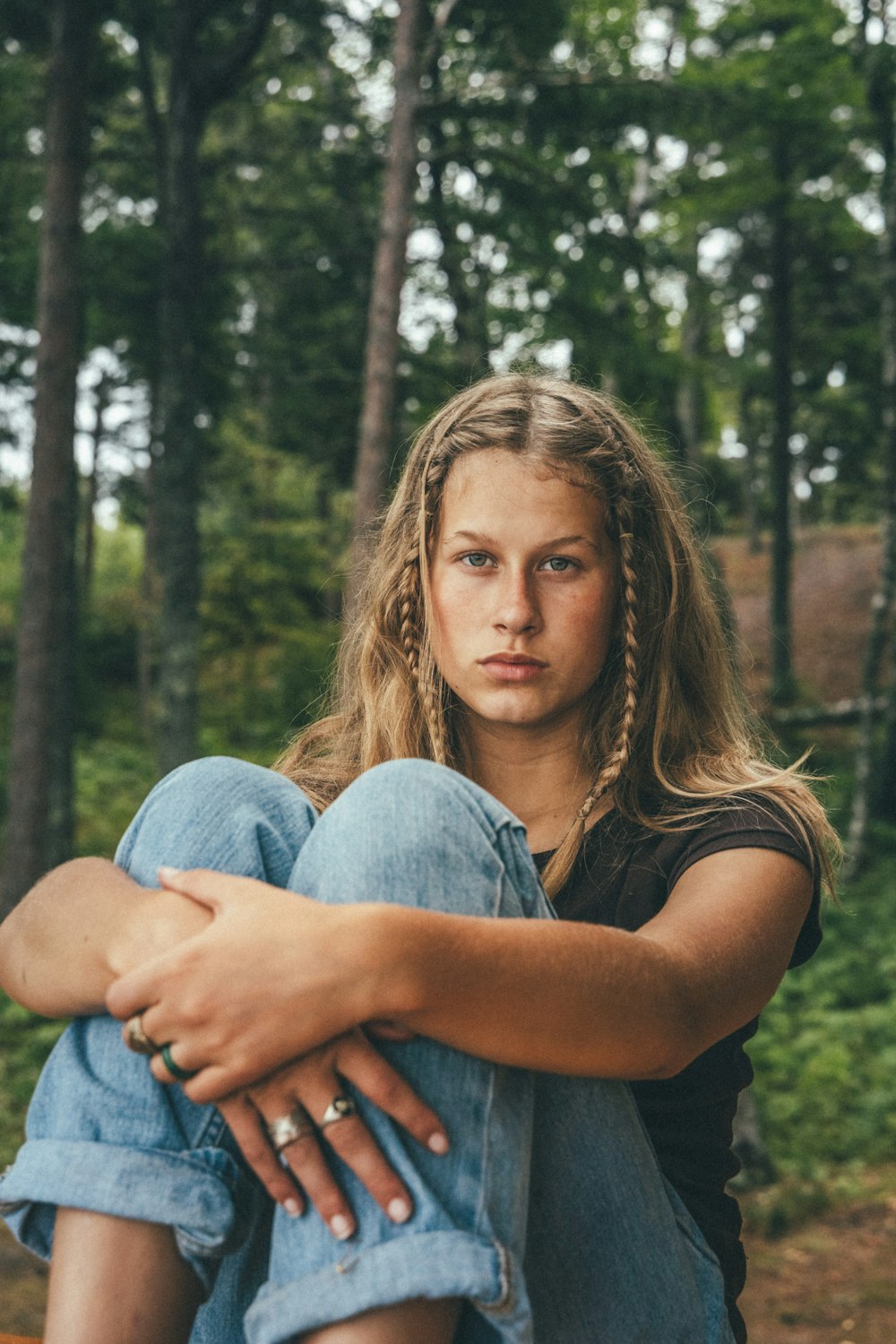 woman in grey shirt and blue denim jeans sitting on ground