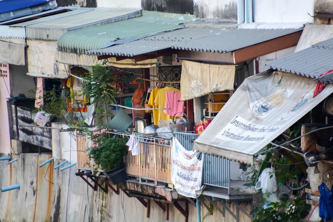 clothes hanged on wire near houses during daytime