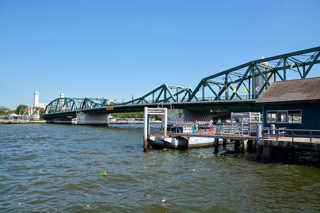 white boat on water under bridge during daytime