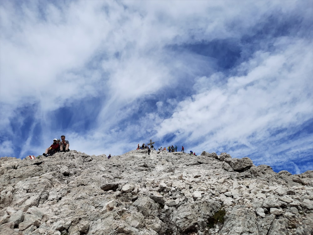 Menschen, die tagsüber unter weißen Wolken und blauem Himmel auf dem Rocky Mountain wandern