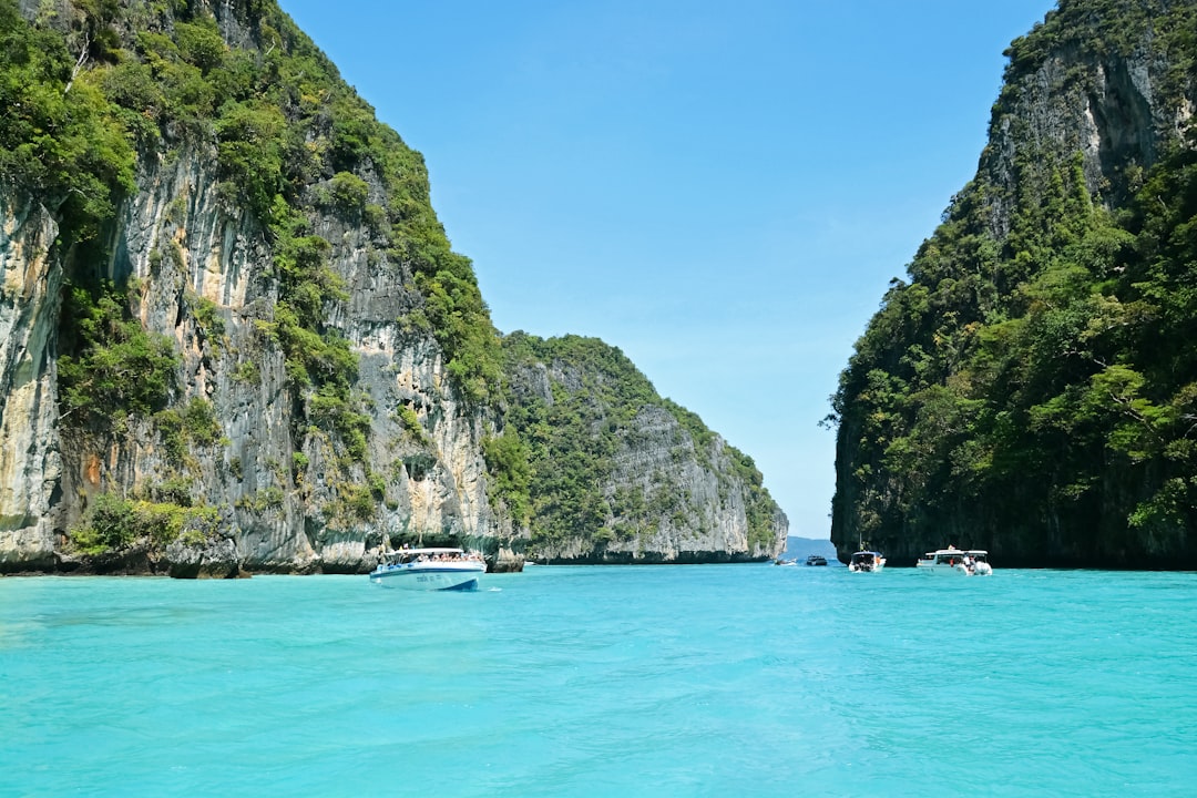 green and gray rock formation beside blue sea under blue sky during daytime