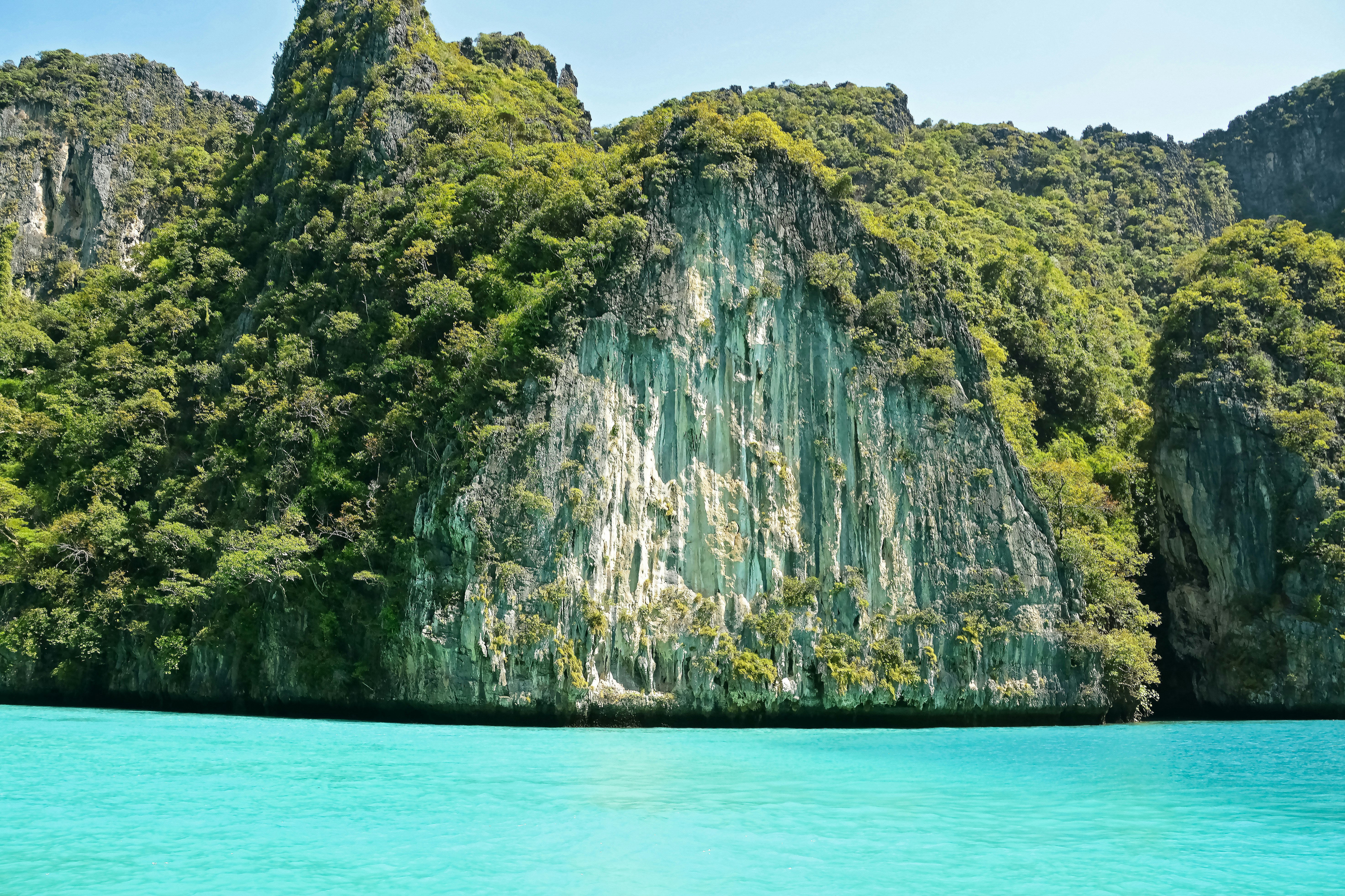 green and brown mountain beside body of water during daytime