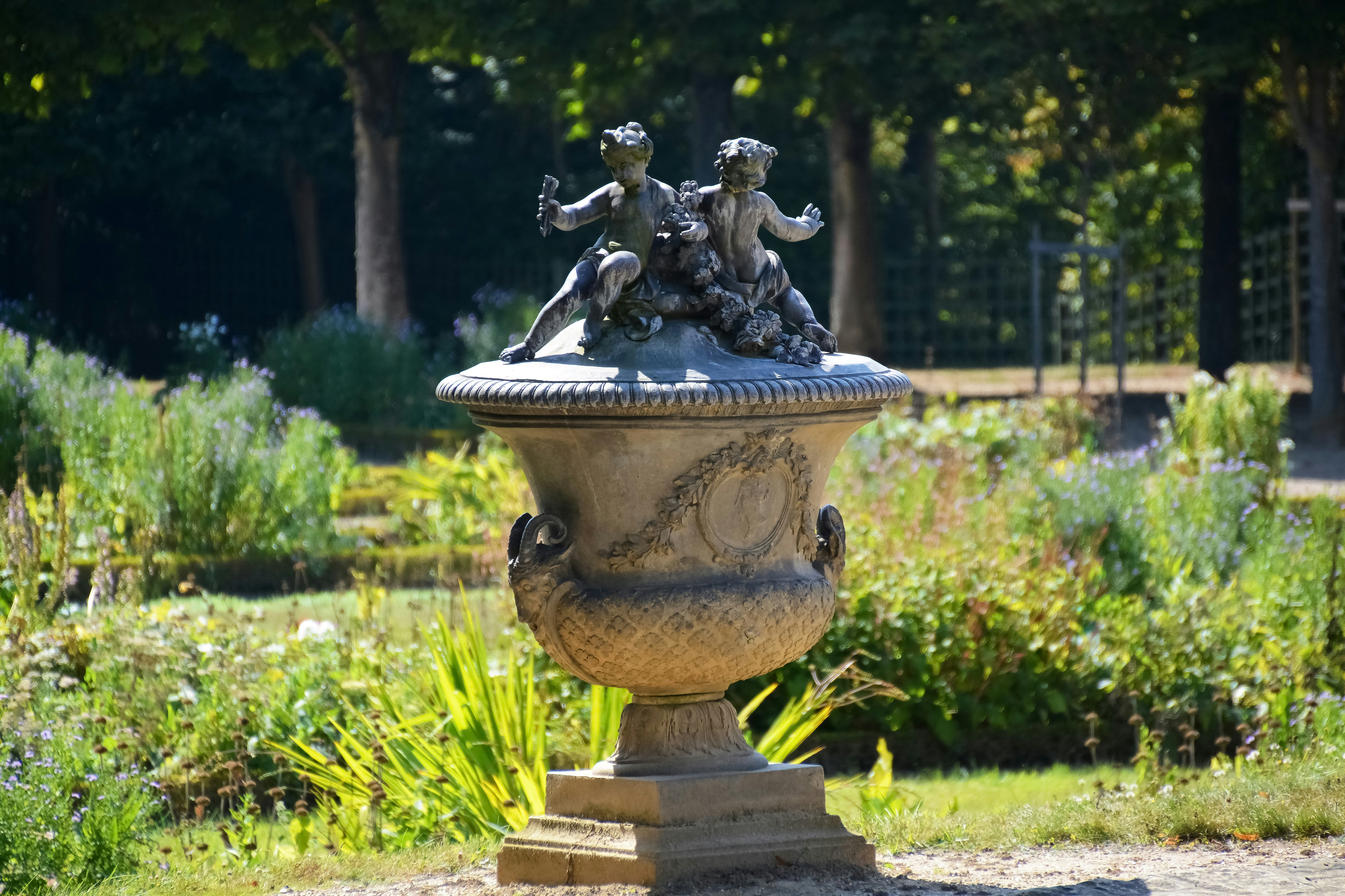 grey concrete statue on green grass field during daytime