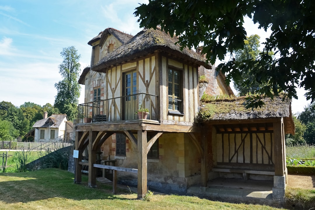 brown wooden house near green trees during daytime