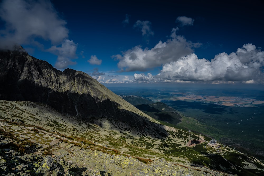 gray and green mountain under blue sky and white clouds during daytime