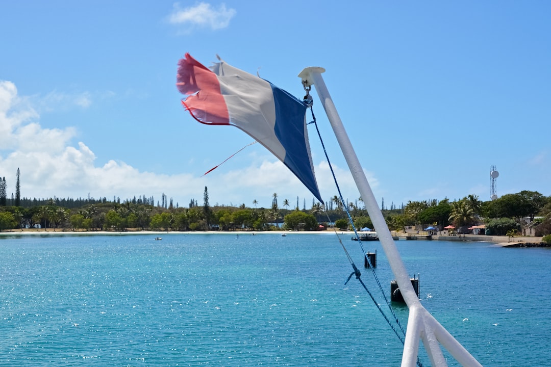 white and red flag on white boat on sea during daytime