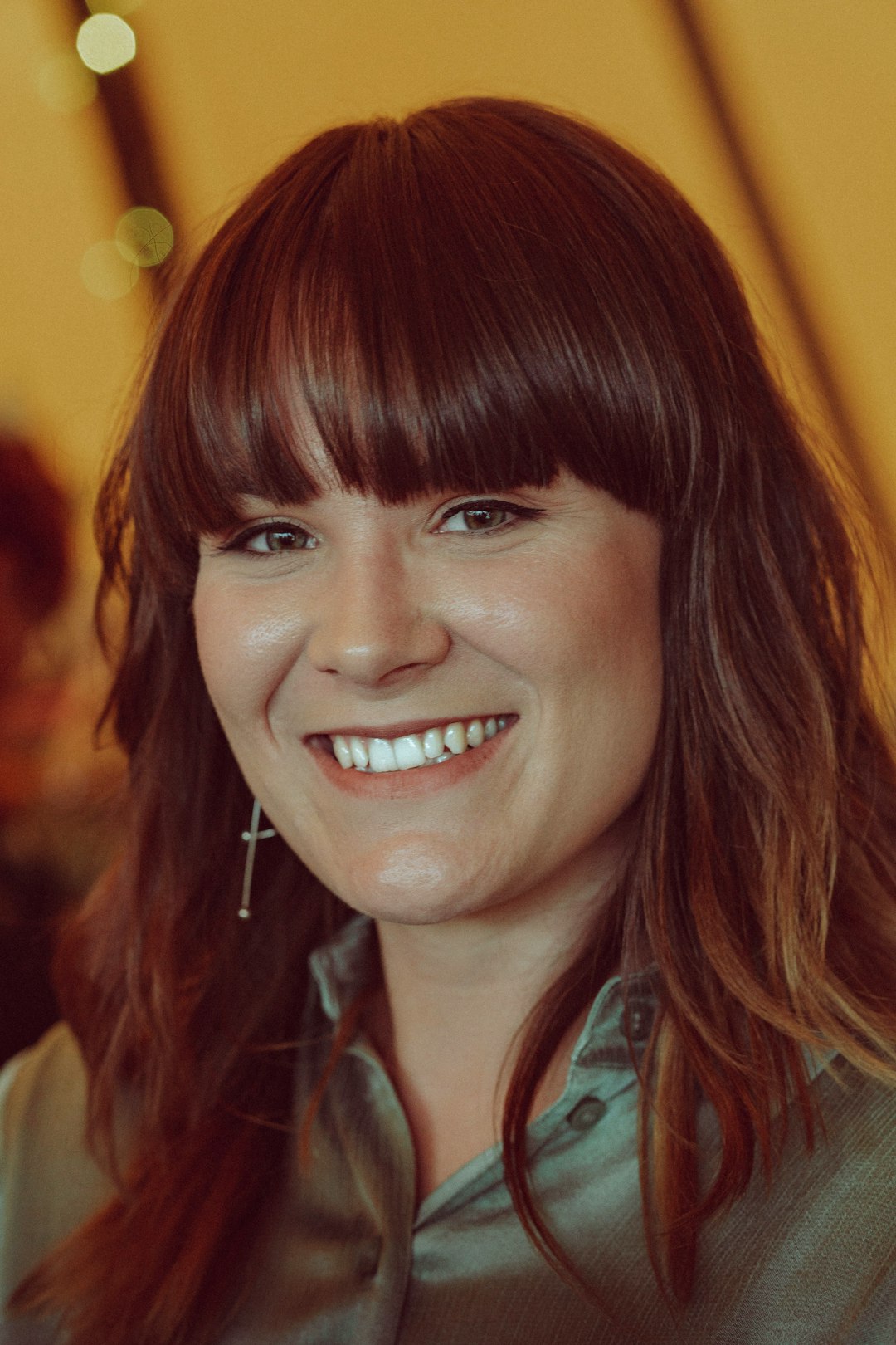 woman in blue and white plaid collared shirt smiling