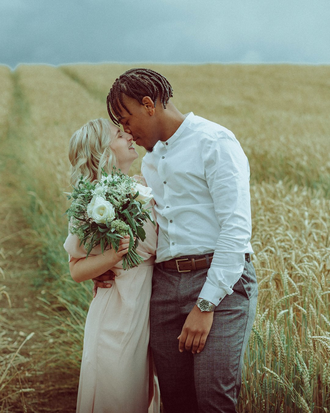 man in white dress shirt holding bouquet of flowers