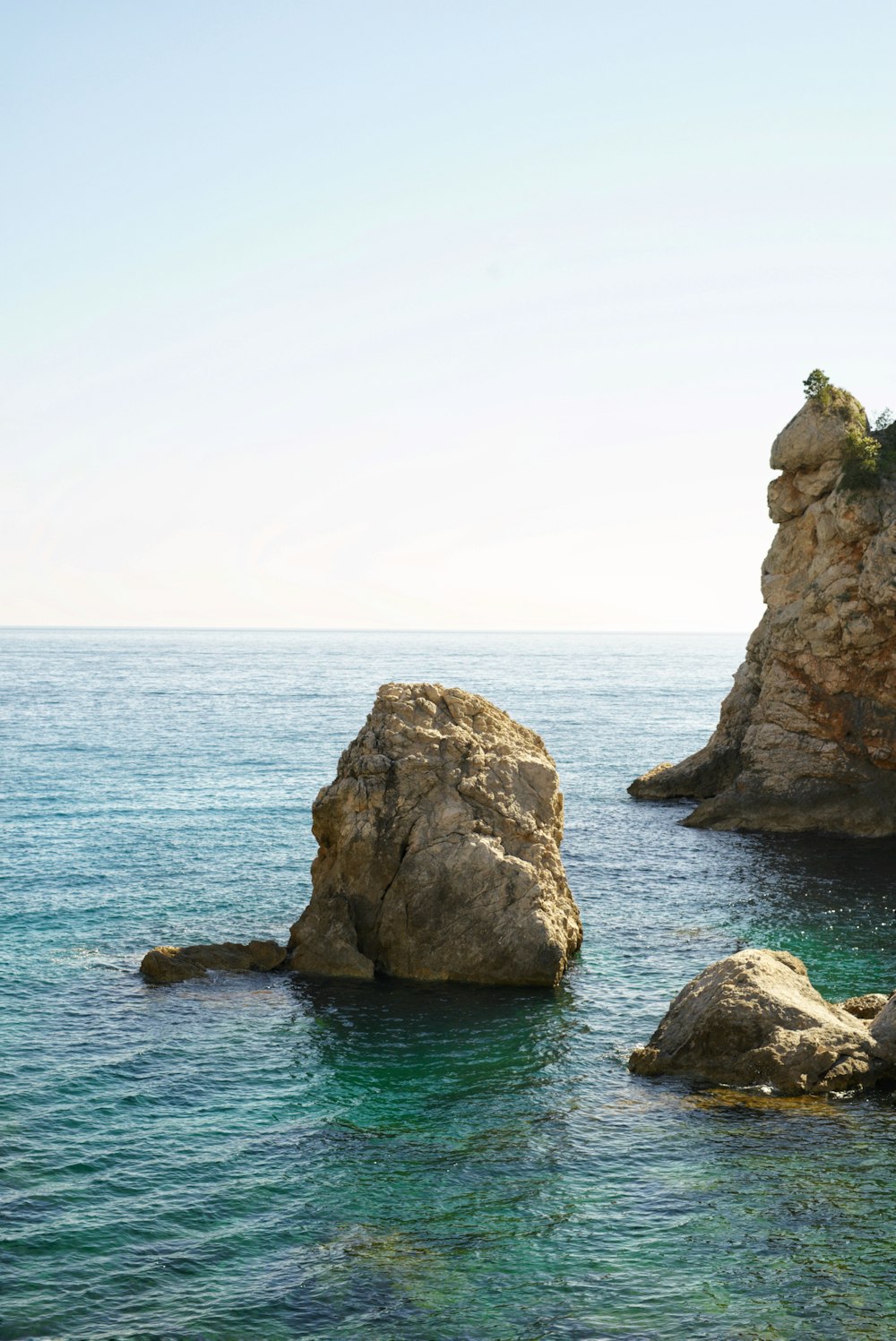 brown rock formation on body of water during daytime