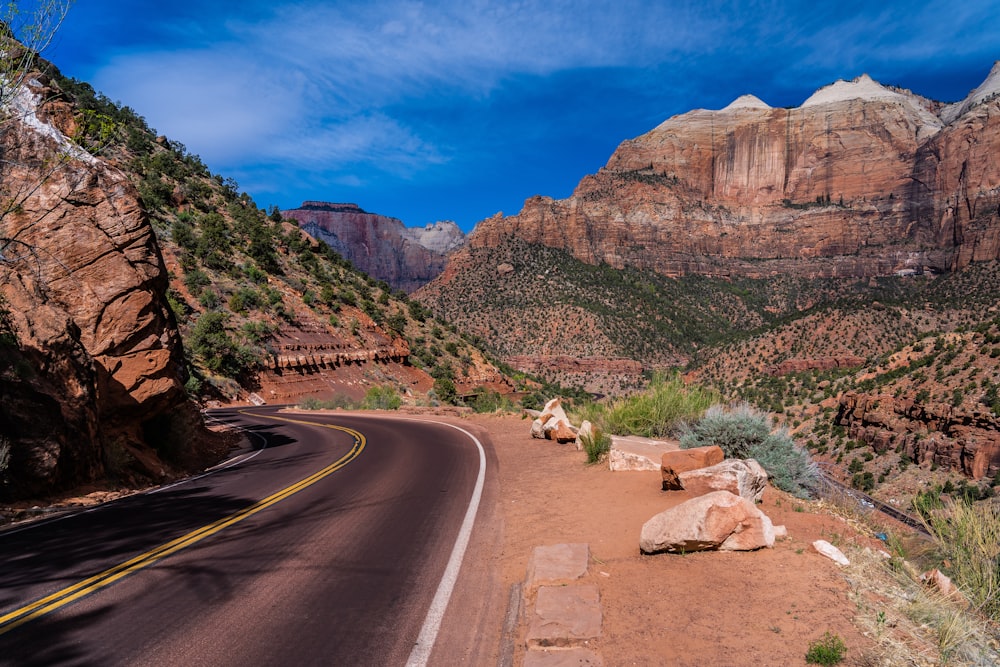 gray asphalt road between brown mountains during daytime