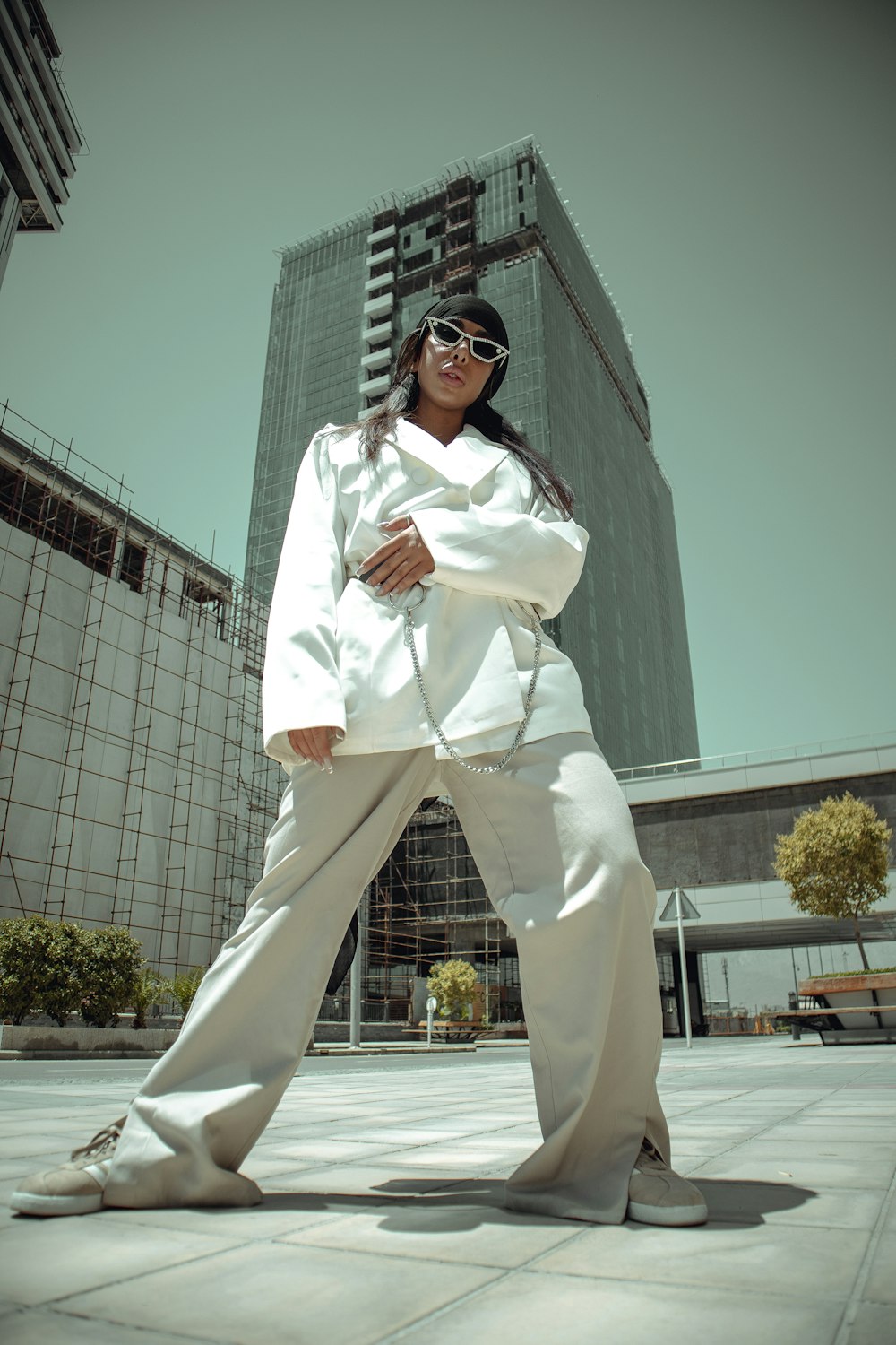 woman in white long sleeve shirt and white pants standing near white building during daytime