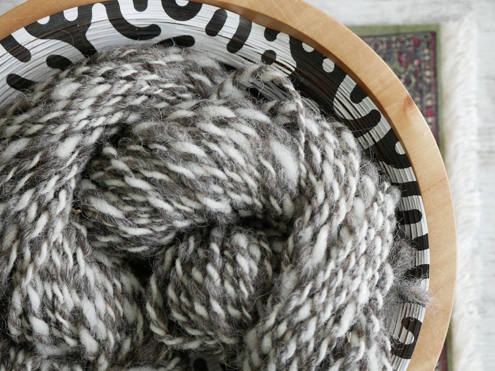 white and gray yarn on brown wooden round table