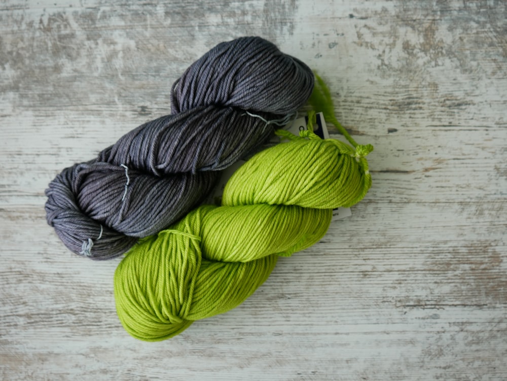 green yarn on brown wooden table