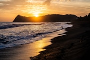 silhouette of person surfing on sea during sunset