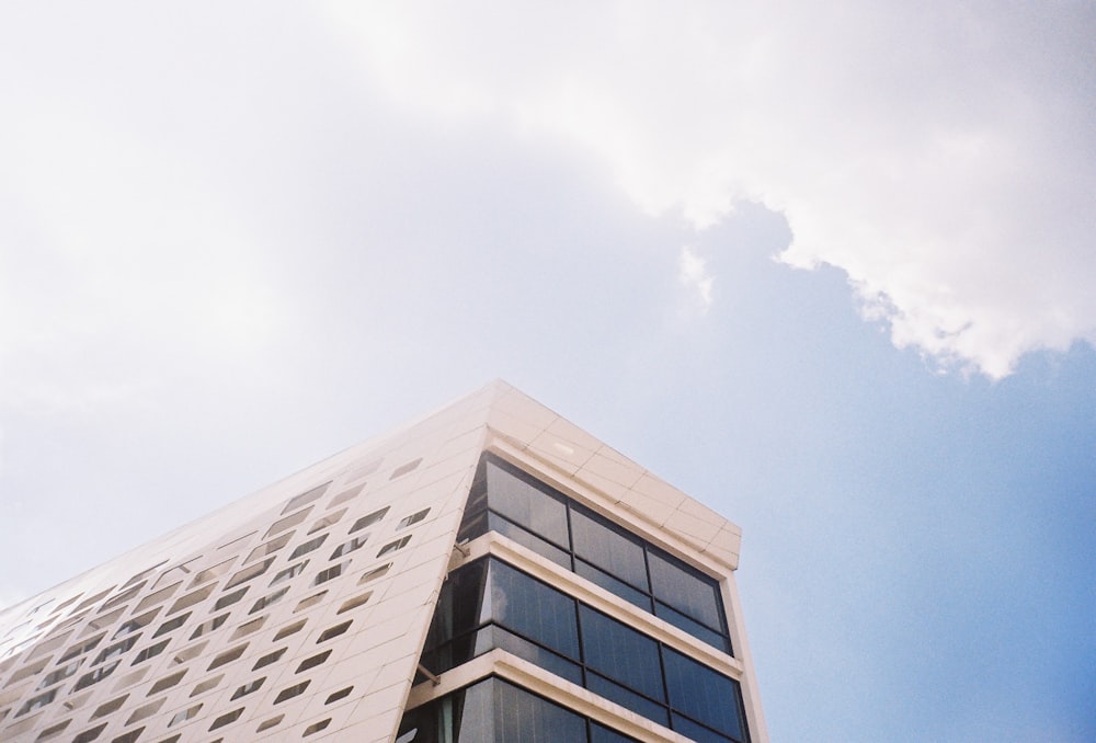 edifício de concreto branco e azul sob nuvens brancas durante o dia