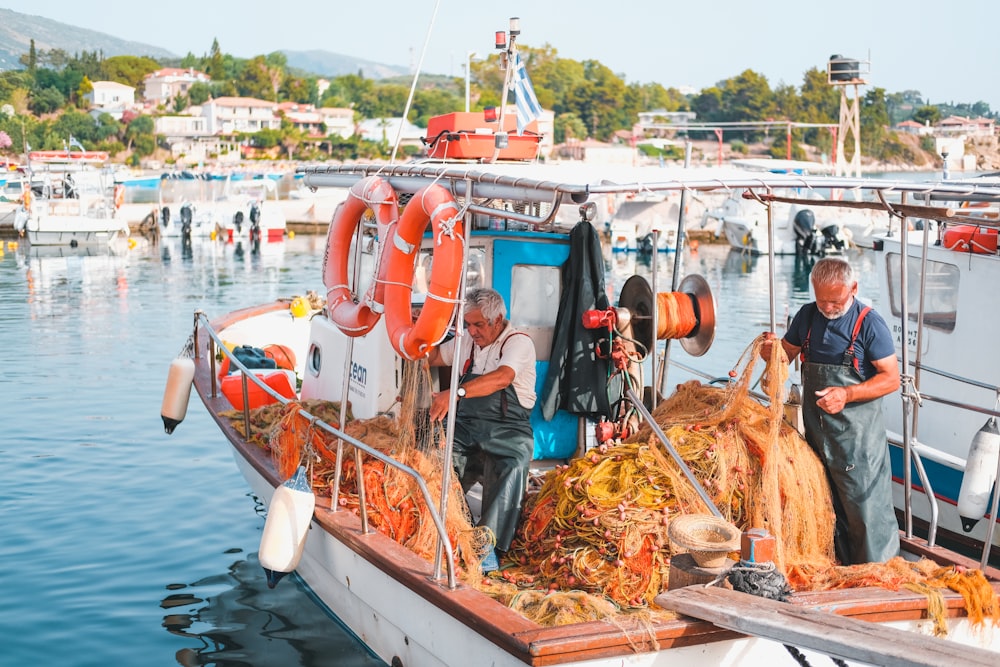 man in blue jacket standing on boat during daytime