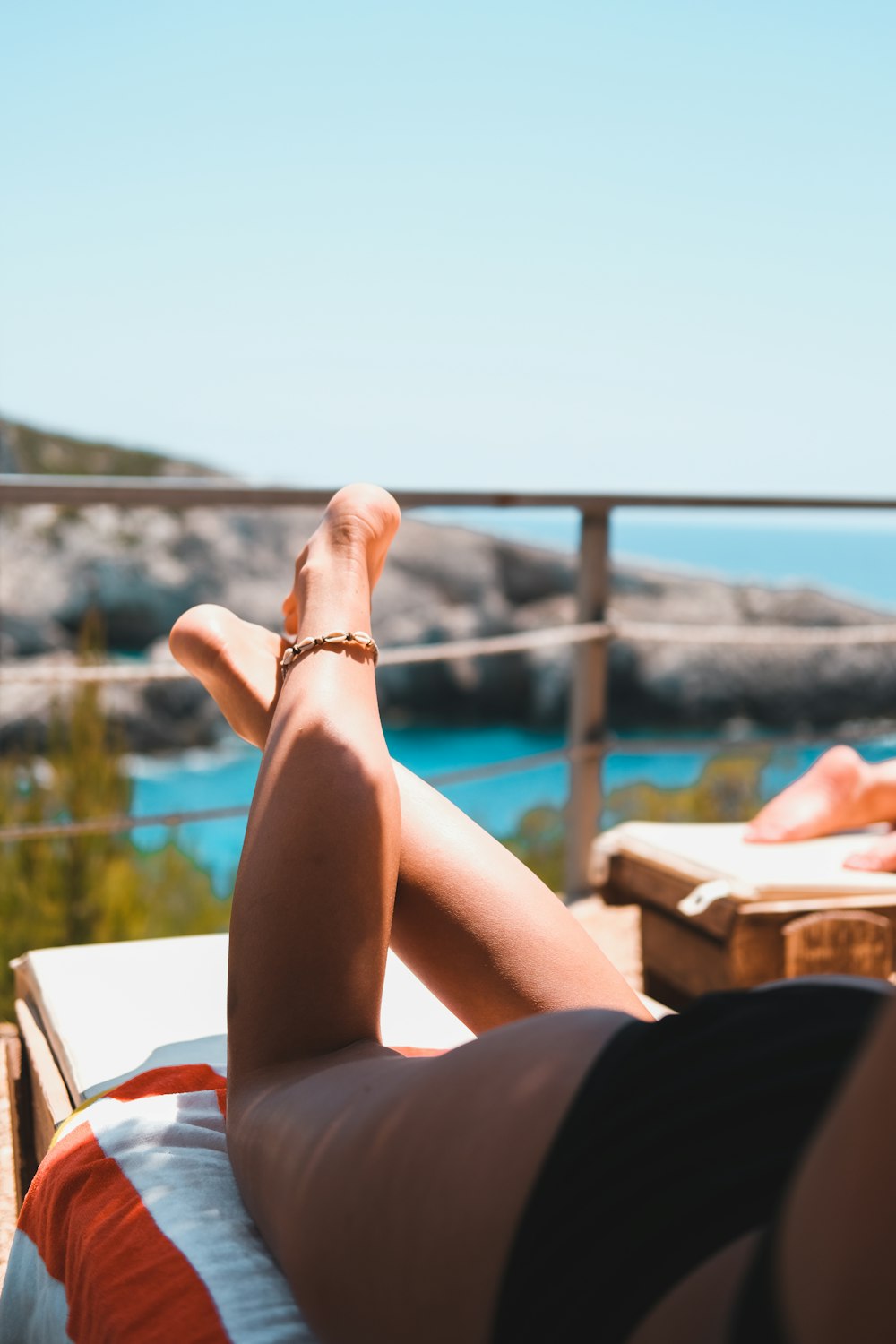 person wearing gold bracelet and bracelet sitting on brown wooden bench during daytime