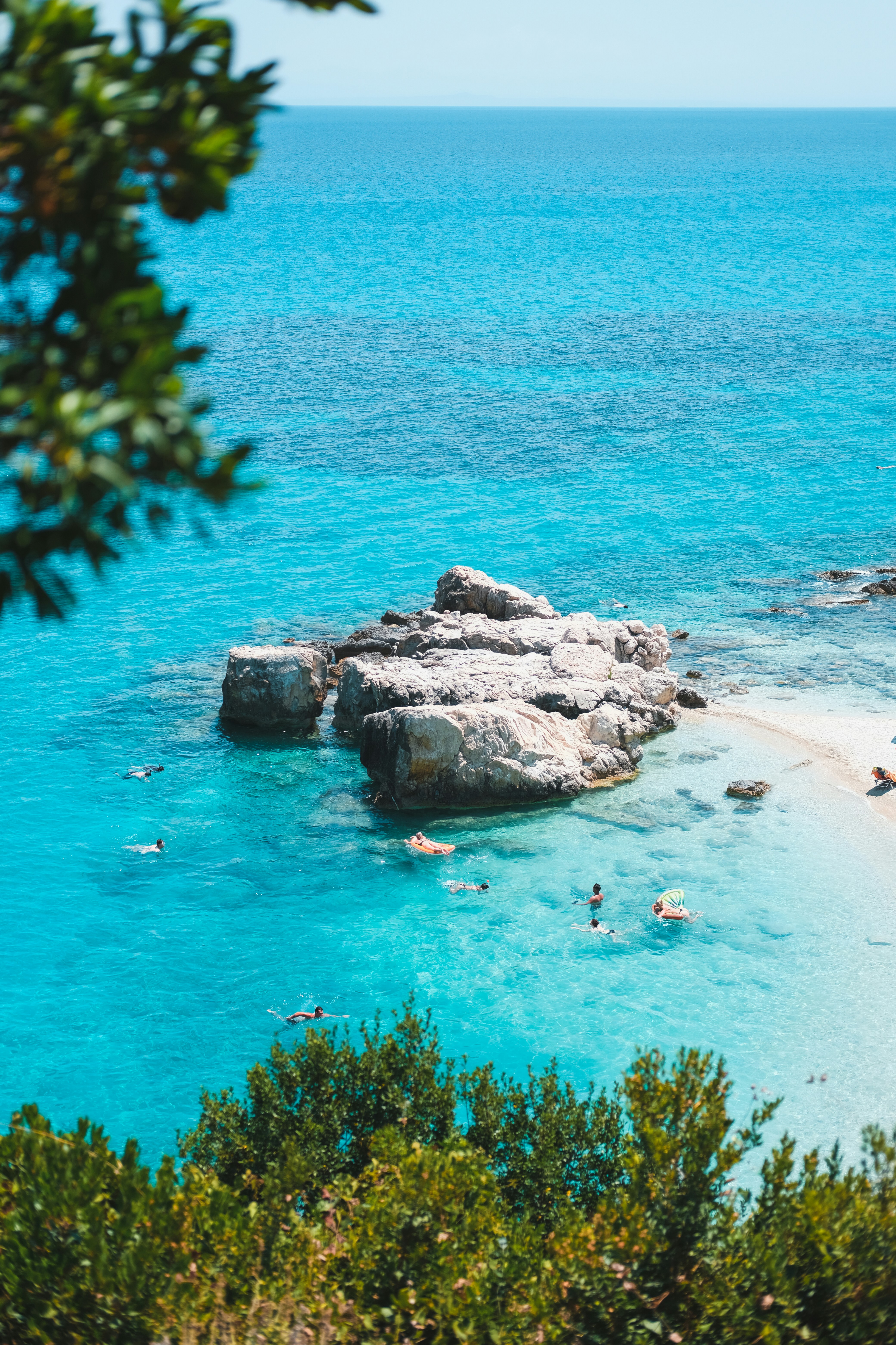 people swimming on sea during daytime