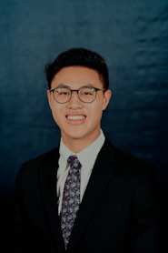 man in black suit wearing eyeglasses