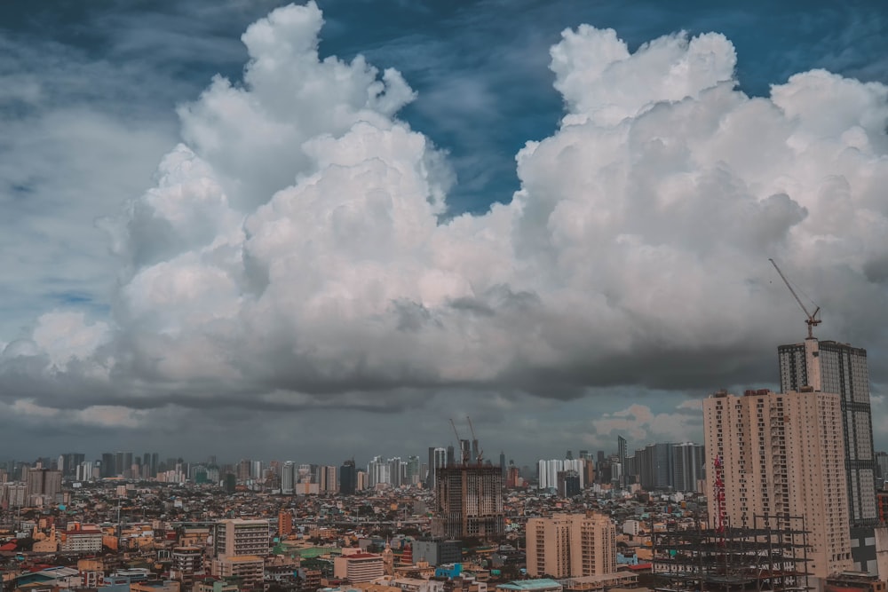 city with high rise buildings under white clouds and blue sky during daytime