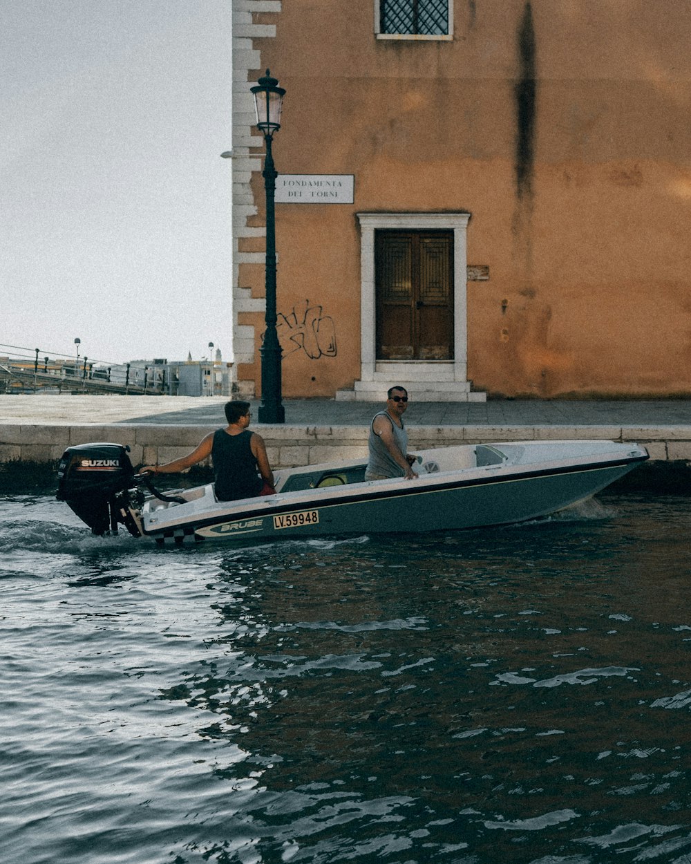 man and woman riding on white and red boat during daytime