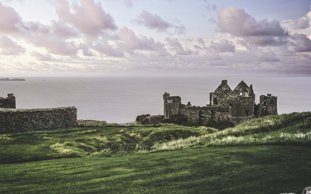 gray concrete castle on green grass field near body of water during daytime