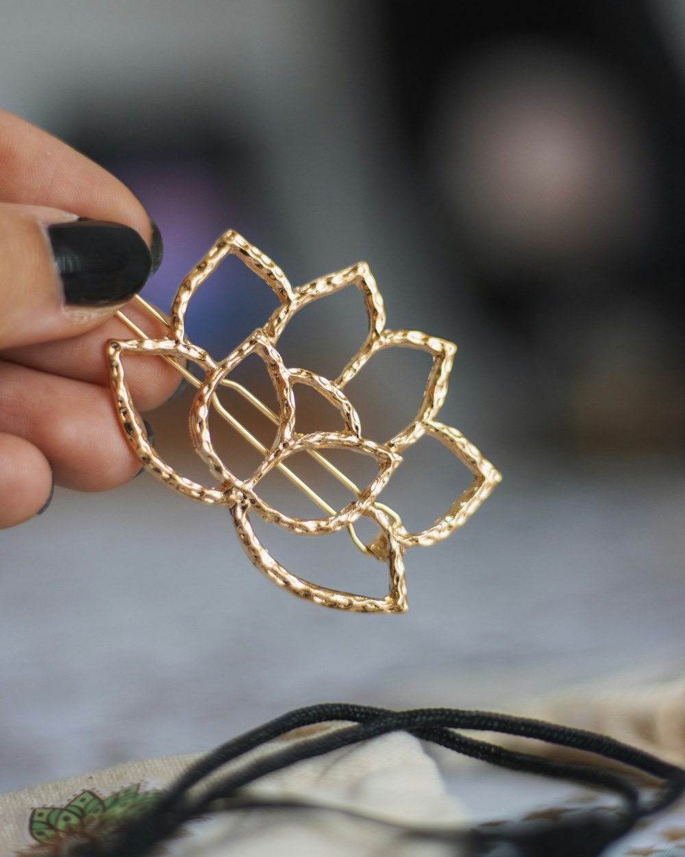 person holding gold beaded necklace