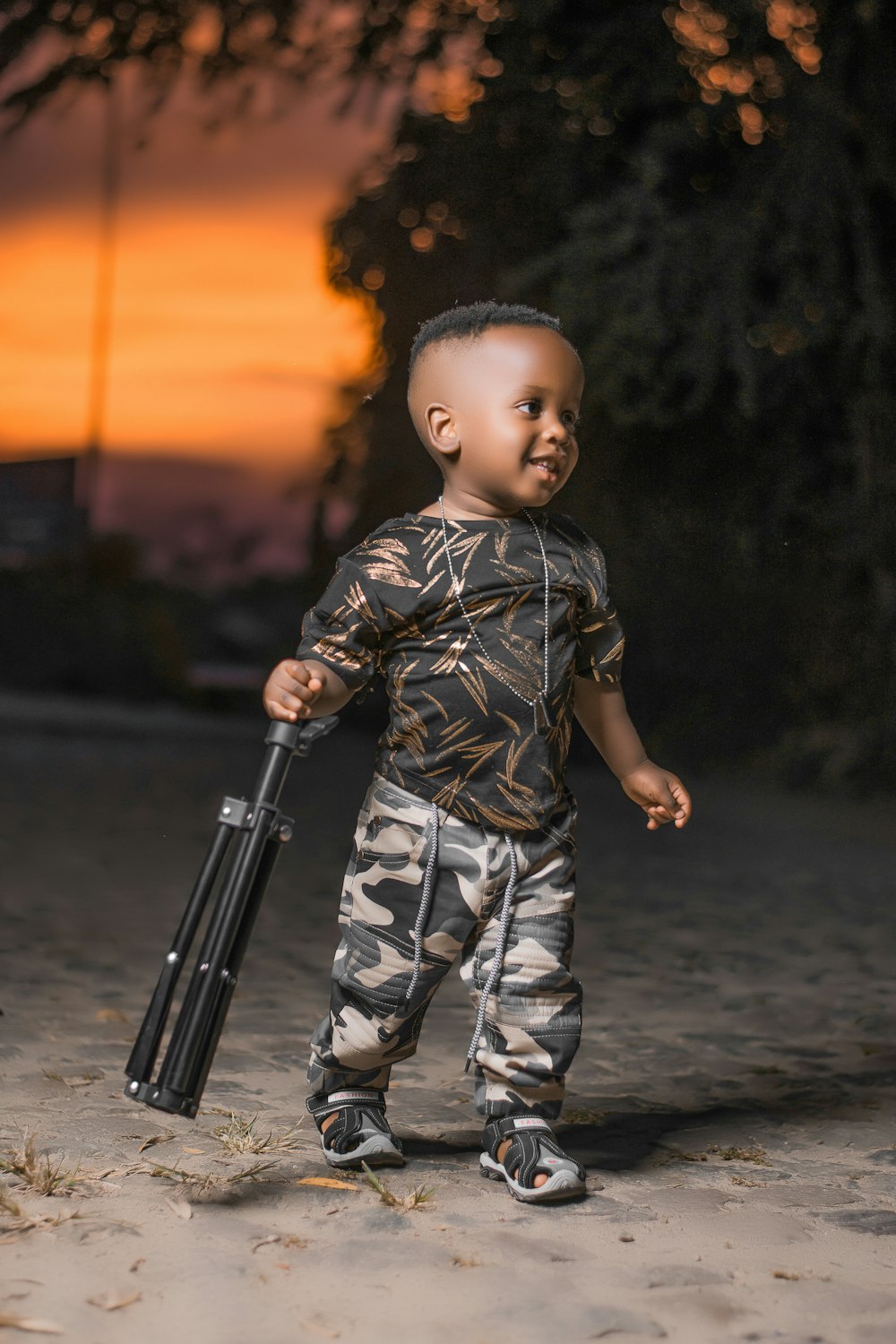 boy in camouflage shirt holding black rifle