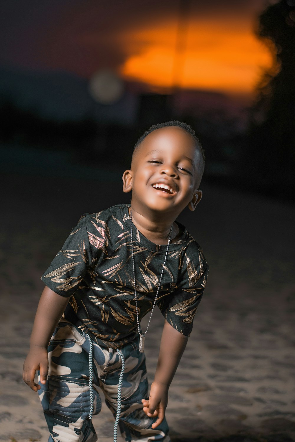 boy in black and white button up shirt standing on gray sand during daytime