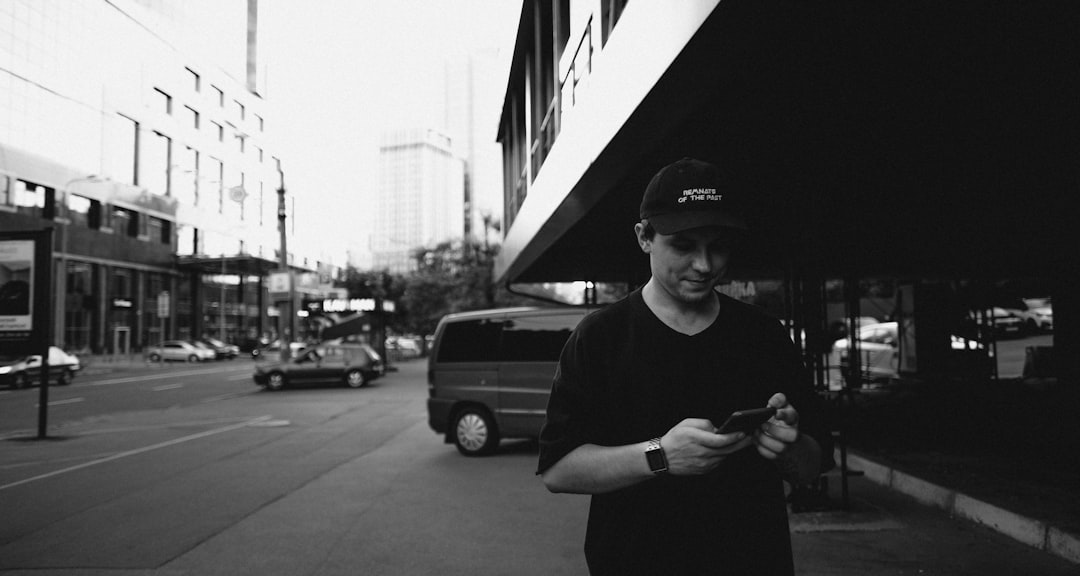 man in black crew neck t-shirt and black cap standing near building during daytime