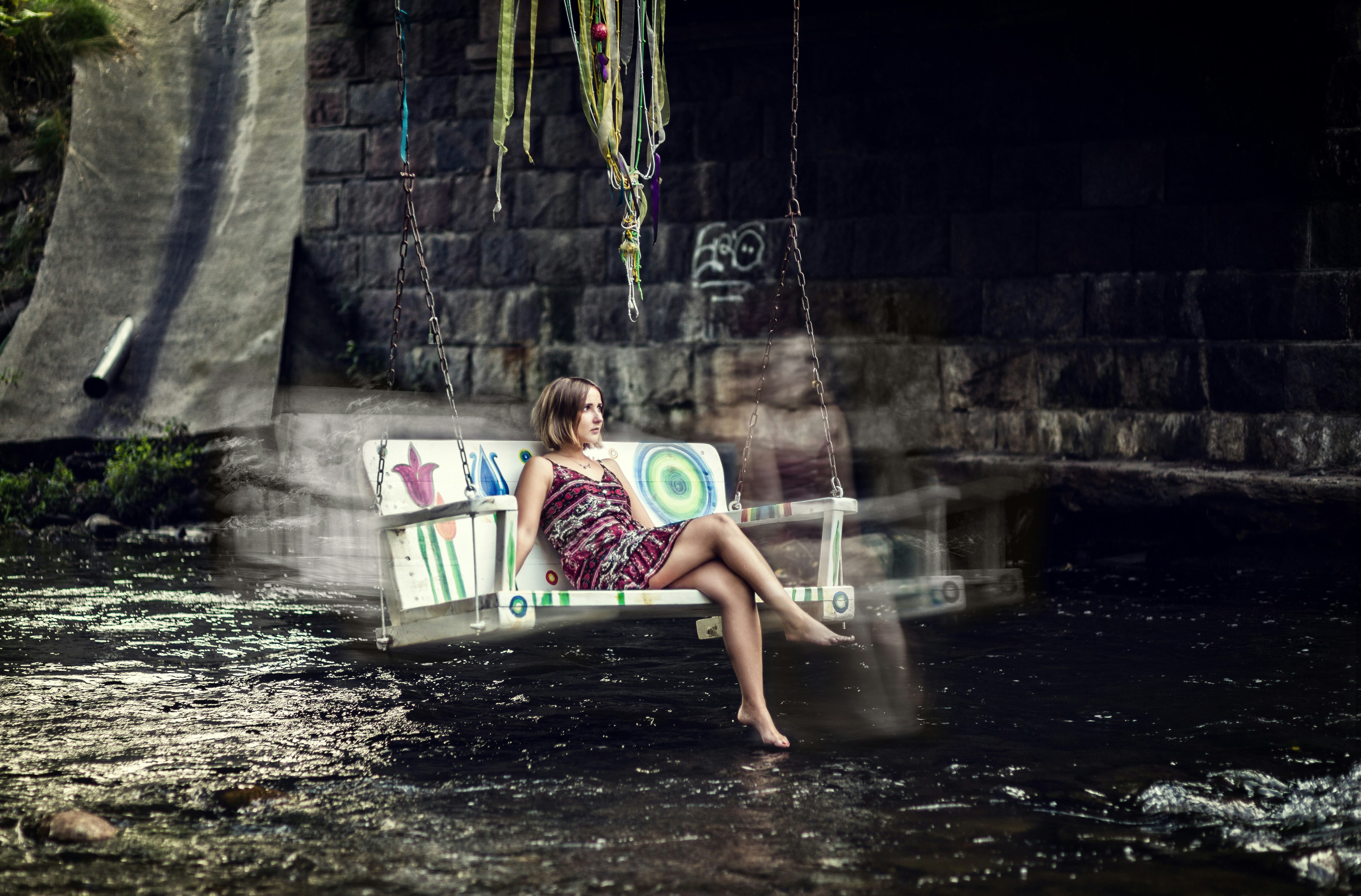 girl in pink and white tank top lying on hammock