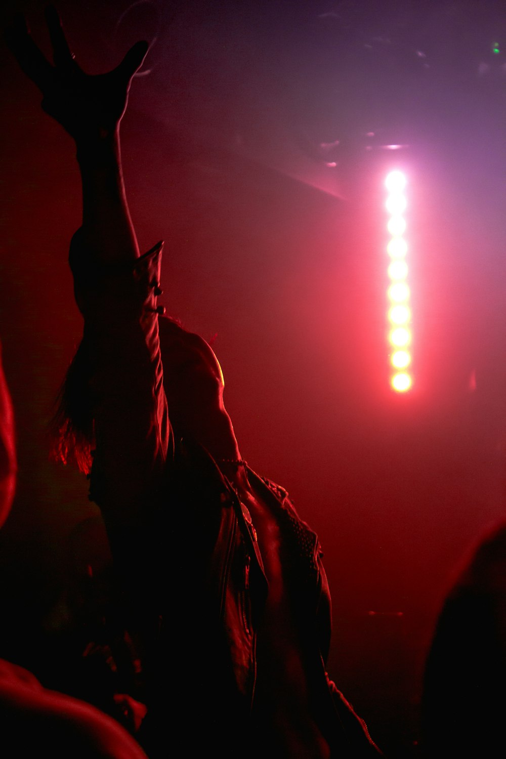 people raising their hands during concert