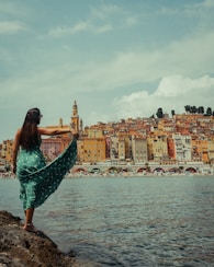 woman in green dress standing on beach during daytime