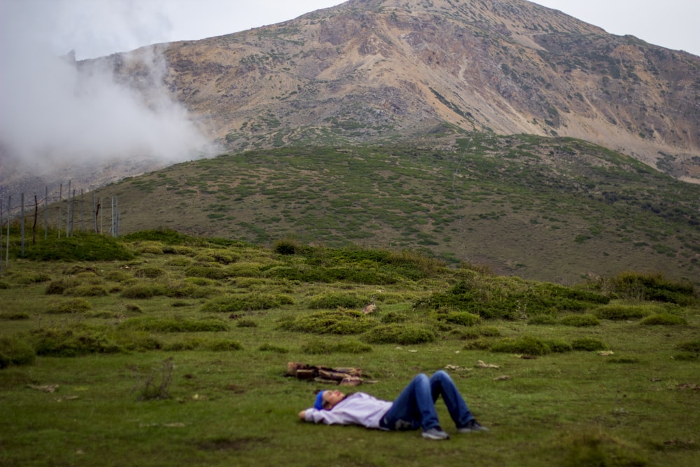 people sitting on green grass field near mountain during daytime