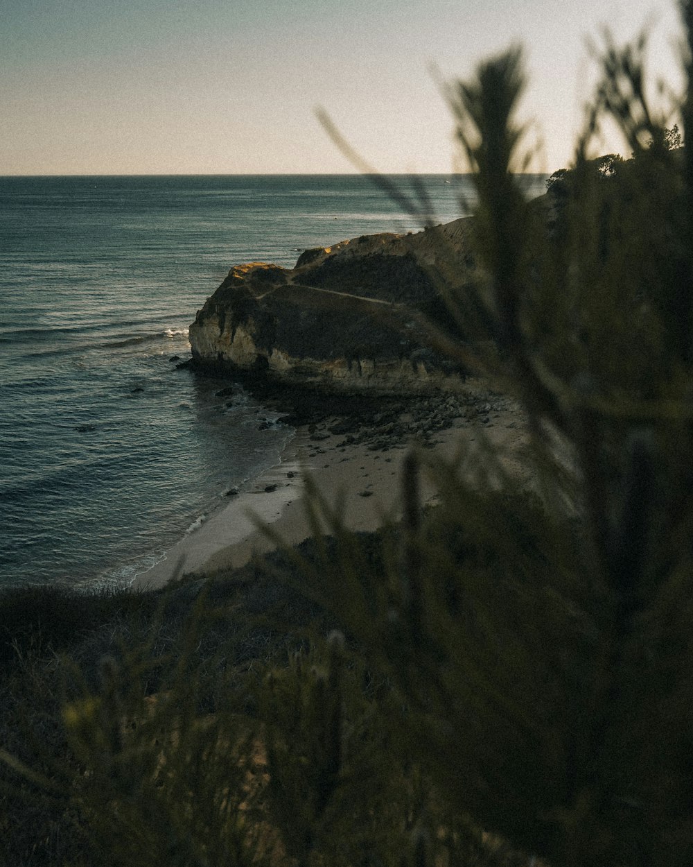 brown rock formation beside body of water during daytime