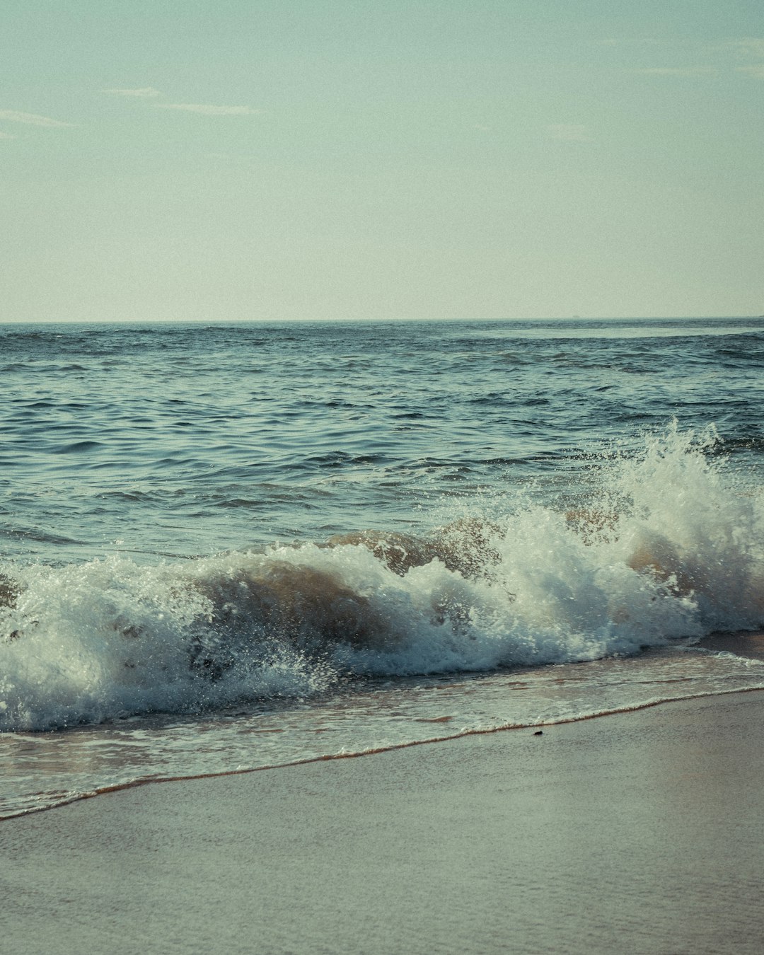 ocean waves crashing on shore during daytime