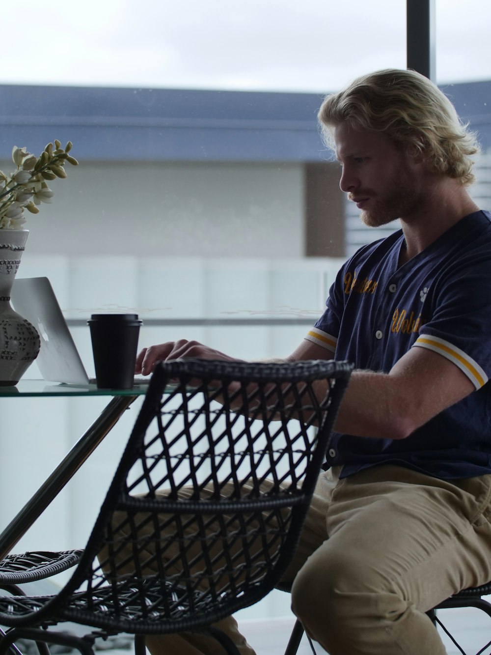 woman in blue and yellow shirt sitting on black metal chair