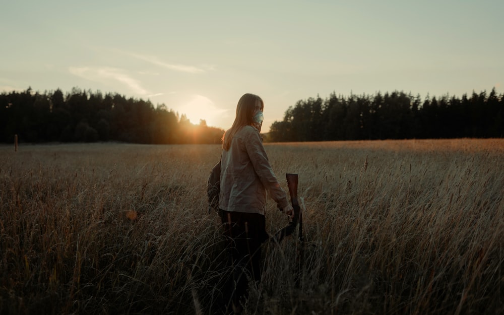 woman in white long sleeve shirt standing on brown grass field during daytime