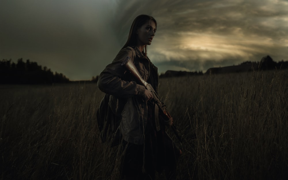 woman in black jacket standing on grass field during daytime