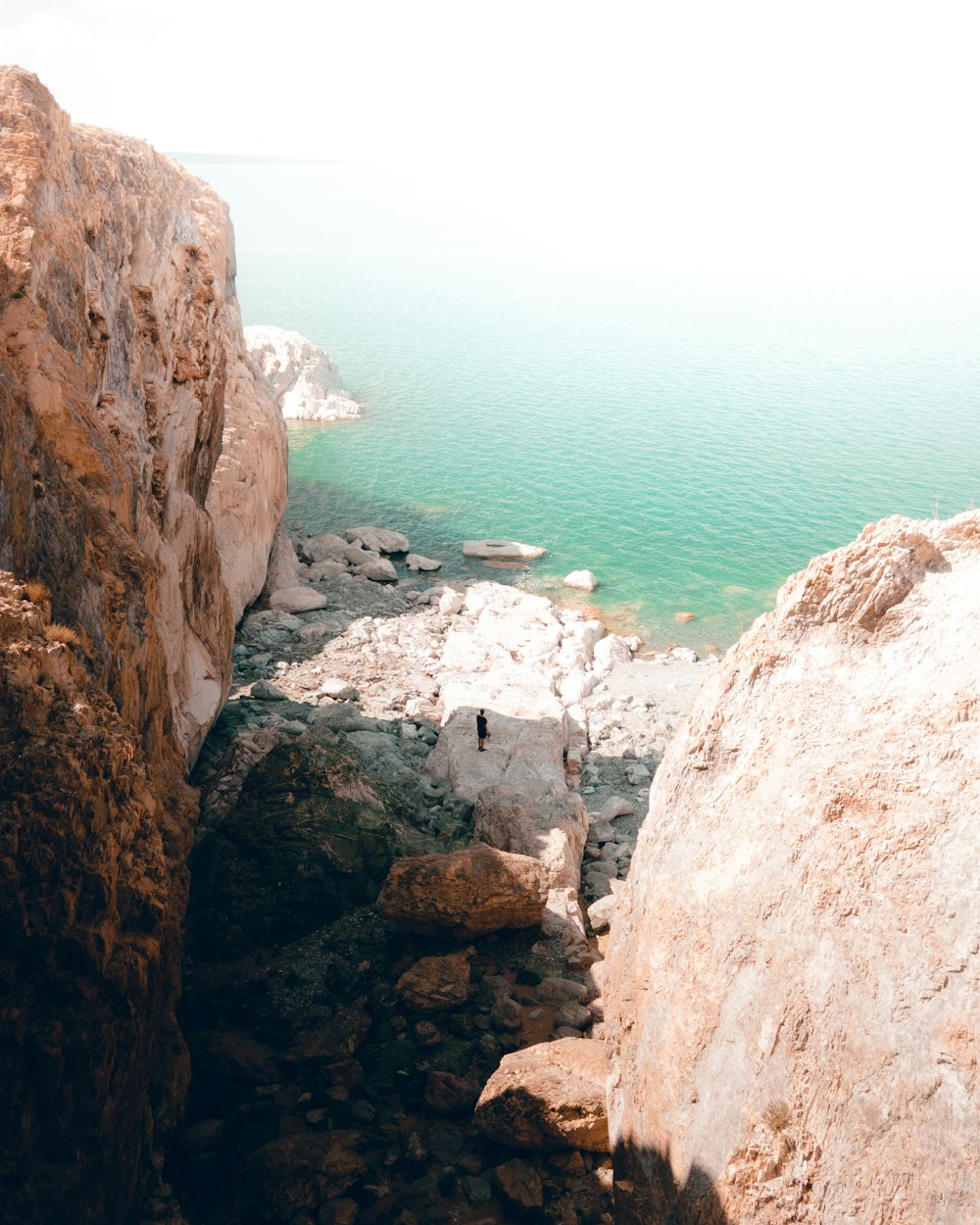 brown rocky mountain near body of water during daytime