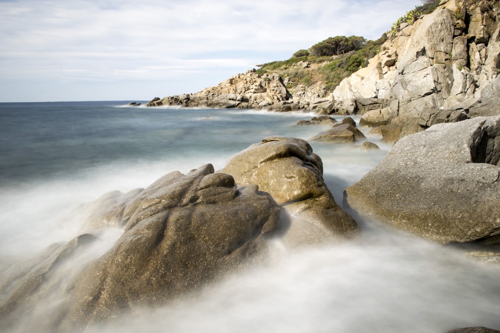 brown rock formation on sea during daytime