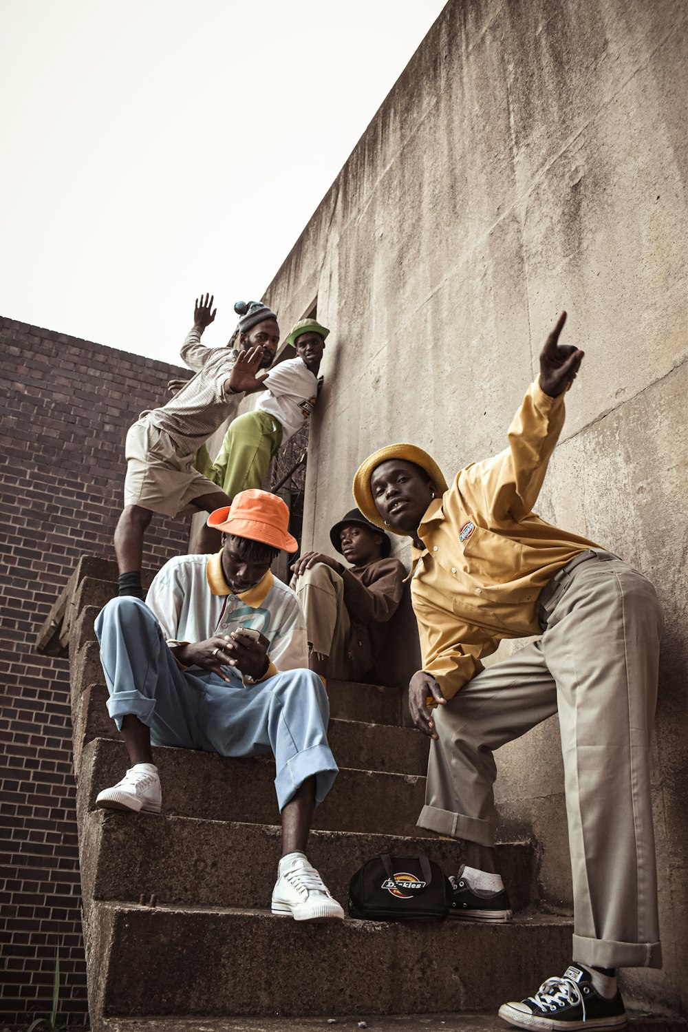 man in brown thobe sitting on concrete stairs