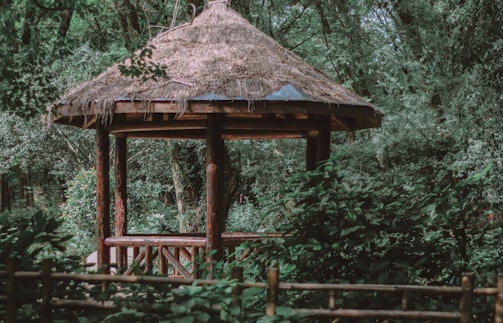 A rustic wooden gazebo integrated seamlessly into a naturalistic garden setting.