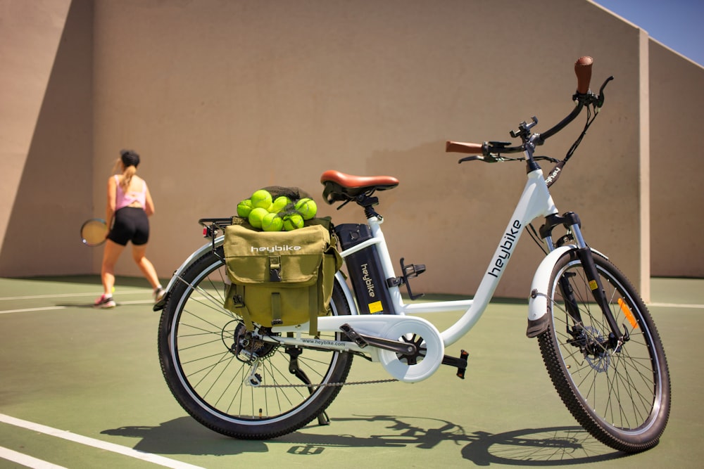 white and black bicycle with green fruit on top